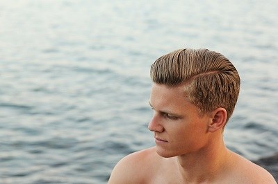 young man with thick and great looking hair standing next to Pacific Ocean